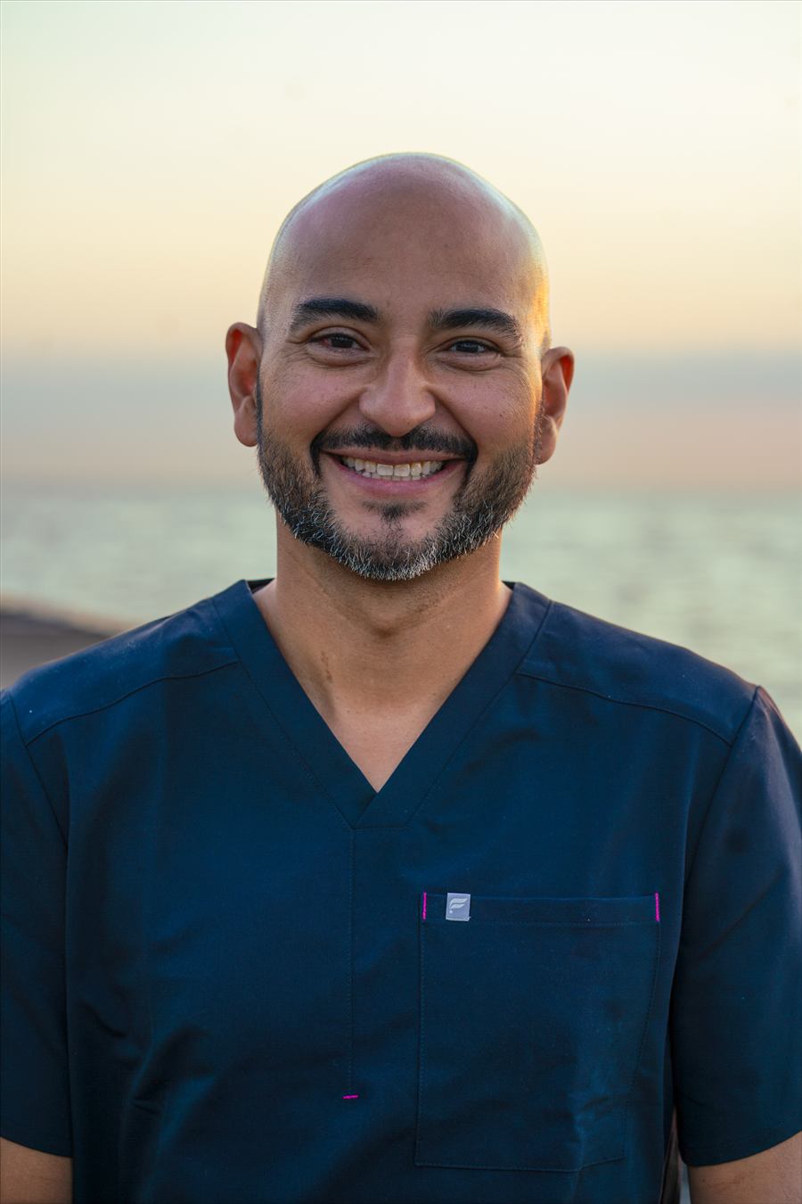 Rios, licensed massage therapist, smiling outdoors along the Chicago lakefront